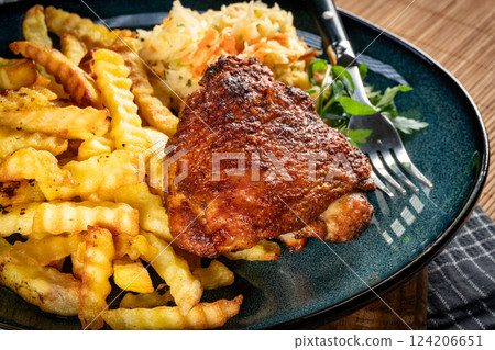 Crispy roasted chicken piece with french fries and salad. 124206651