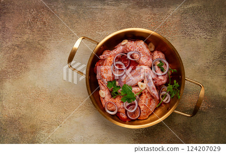Chicken wings, in a brass saucepan, ready for cooking, grilling or baking, in a home kitchen, no people Chicken wings, in a brass saucepan, ready for cooking, grilling or baking, in a home kitchen, no people 124207029