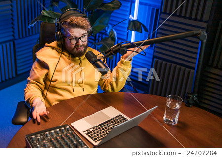 Handsome man radio DJ hosting a radio show, entertainment and communication concept 124207284