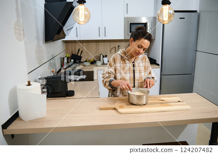 Woman Making Crepes in Modern Kitchen for Healthy Homemade Meal Woman Making Crepes in Modern Kitchen for Healthy Homemade Meal 124207482
