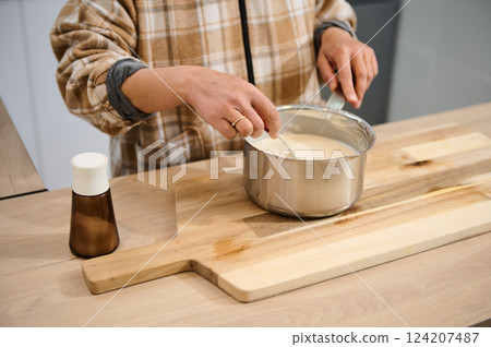 Woman Cooking in Kitchen With Batter on Wood Cutting Board Woman Cooking in Kitchen With Batter on Wood Cutting Board 124207487