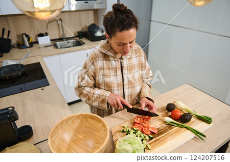 Woman Preparing Fresh Vegetable Salad in a Modern Kitchen 124207516