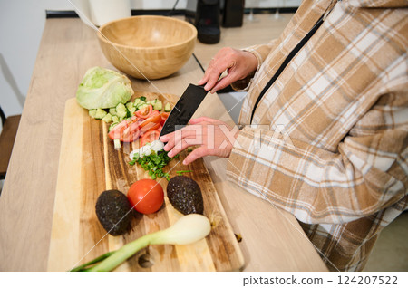 Preparing Fresh Salad Ingredients in a Comfortable Home Kitchen Setting Preparing Fresh Salad Ingredients in a Comfortable Home Kitchen Setting 124207522