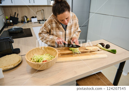 Woman Preparing Healthy Salad and Tortillas in a Modern Kitchen Setting Woman Preparing Healthy Salad and Tortillas in a Modern Kitchen Setting 124207545