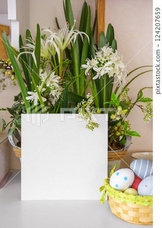 Beautiful vibrant flowers in decorative pot and Easter eggs with square empty display cardboard 124207659