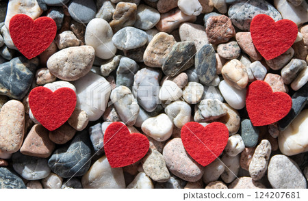 Much red bright fabric hearts on other stones near the river. Much red bright fabric hearts on other stones near the river. 124207681