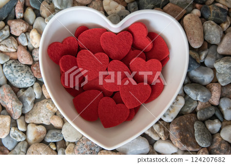 Red bright fabric hearts in romantic plate on other stones. Red bright fabric hearts in romantic plate on other stones. 124207682
