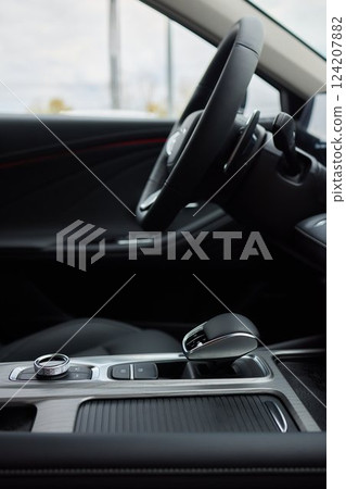 Selector automatic transmission with leather in the interior of a modern expensive car. The background is blurred. Black and brown leather car. Selector automatic transmission with leather in the interior of a modern expensive car. The background is blurred. Black and brown leather car. 124207882