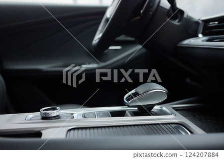 Selector automatic transmission with leather in the interior of a modern expensive car. The background is blurred. Black and brown leather car. Selector automatic transmission with leather in the interior of a modern expensive car. The background is blurred. Black and brown leather car. 124207884