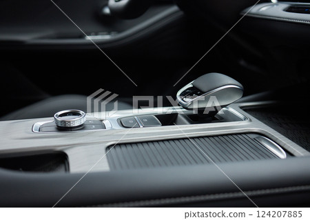 Selector automatic transmission with leather in the interior of a modern expensive car. The background is blurred. Black and brown leather car. Selector automatic transmission with leather in the interior of a modern expensive car. The background is blurred. Black and brown leather car. 124207885
