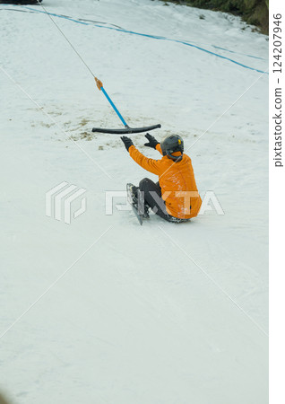 Snow adventure unfolds as an excited skier glides down a snowy slope, embracing the thrill of winter sports in a picturesque mountain landscape during the crisp daylight hours Snow adventure unfolds as an excited skier glides down a snowy slope, embracing the thrill of winter sports in a picturesque mountain landscape during the crisp daylight hours 124207946