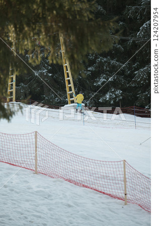 Skiing adventure unfolds in a snowy landscape under tall trees with a bright yellow figure ascending a winter wonderland Skiing adventure unfolds in a snowy landscape under tall trees with a bright yellow figure ascending a winter wonderland 124207954