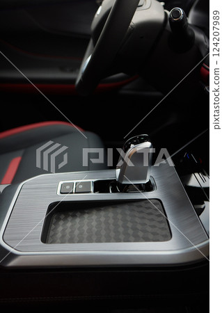Selector automatic transmission with leather in the interior of a modern expensive car. The background is blurred. Black and brown leather car. Selector automatic transmission with leather in the interior of a modern expensive car. The background is blurred. Black and brown leather car. 124207989