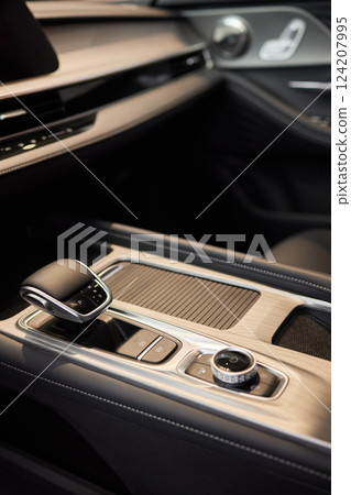Selector automatic transmission with leather in the interior of a modern expensive car. The background is blurred. Black and brown leather car. Selector automatic transmission with leather in the interior of a modern expensive car. The background is blurred. Black and brown leather car. 124207995