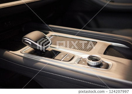 Selector automatic transmission with leather in the interior of a modern expensive car. The background is blurred. Black and brown leather car. Selector automatic transmission with leather in the interior of a modern expensive car. The background is blurred. Black and brown leather car. 124207997