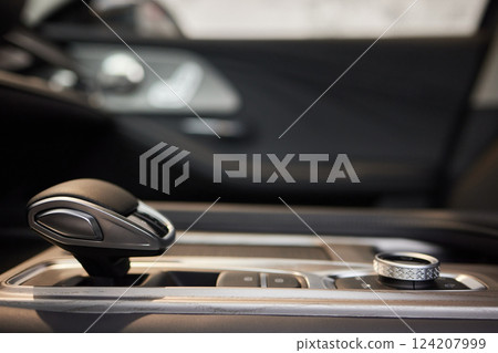 Selector automatic transmission with leather in the interior of a modern expensive car. The background is blurred. Black and brown leather car. Selector automatic transmission with leather in the interior of a modern expensive car. The background is blurred. Black and brown leather car. 124207999
