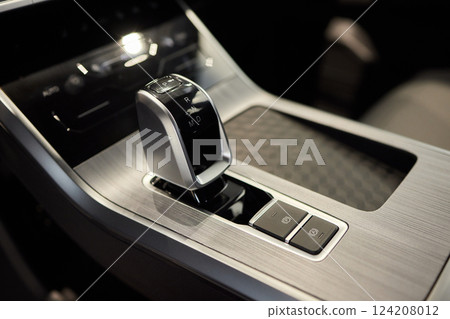Selector automatic transmission with leather in the interior of a modern expensive car. The background is blurred. Black and brown leather car. 124208012