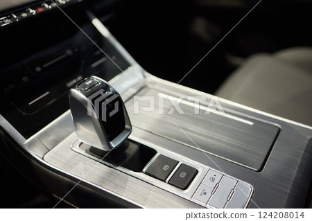 Selector automatic transmission with leather in the interior of a modern expensive car. The background is blurred. Black and brown leather car. Selector automatic transmission with leather in the interior of a modern expensive car. The background is blurred. Black and brown leather car. 124208014