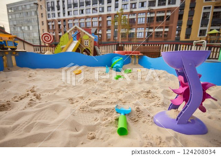 Toys are scattered in a large children's sandbox. Childhood and leisure of kids 124208034