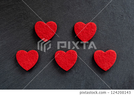 Red hearts made of material fabric on the black stone background. Concept of Valentine's day and romantic love. 124208143