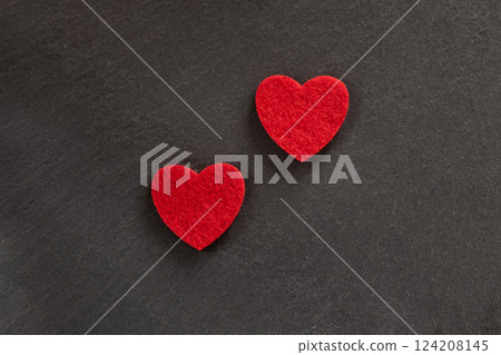 Two red hearts made of material fabric on the black background. Concept of Valentine's day and romantic love. Two red hearts made of material fabric on the black background. Concept of Valentine's day and romantic love. 124208145