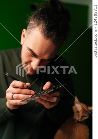 Close-up vertical portrait of focused technician cleaning delicate motherboard components with precision brush, showcasing careful hardware maintenance and electronic repair expertise. Close-up vertical portrait of focused technician cleaning delicate motherboard components with precision brush, showcasing careful hardware maintenance and electronic repair expertise. 124208713