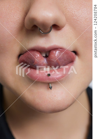 tongue splitting. cutting the tongue, one type of modification of the human body. surgery concept. tongue splitting. cutting the tongue, one type of modification of the human body. surgery concept. 124208784