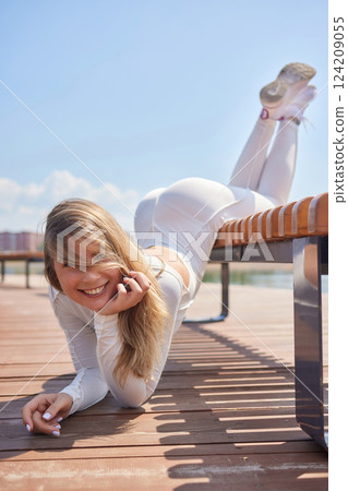 Portrait of fit and sporty young woman doing stretching in city. 124209055