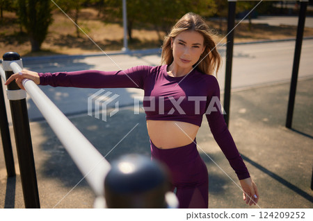 Portrait of fit and sporty young woman doing stretching in city. 124209252