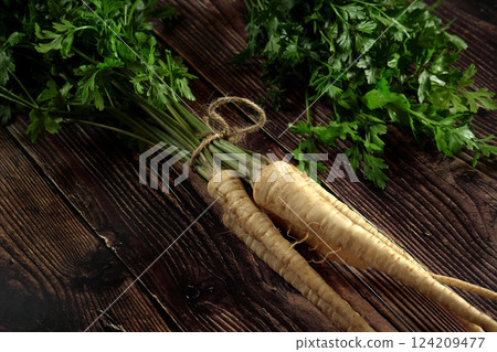 Bunch of parsley roots with green leaves on dark wooden rustic board Bunch of parsley roots with green leaves on dark wooden rustic board 124209477