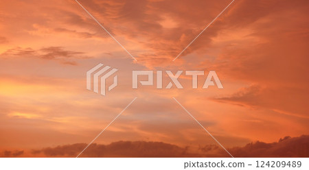 Orange and pink sky after sunset, silhouettes of mountains below - can be used as background with subjects placed in front Orange and pink sky after sunset, silhouettes of mountains below - can be used as background with subjects placed in front 124209489