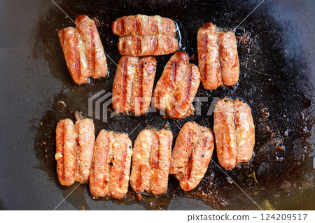 Small bratwurst / hot dog frankfurter sausages grilled on electric grill, view from above Small bratwurst / hot dog frankfurter sausages grilled on electric grill, view from above 124209517