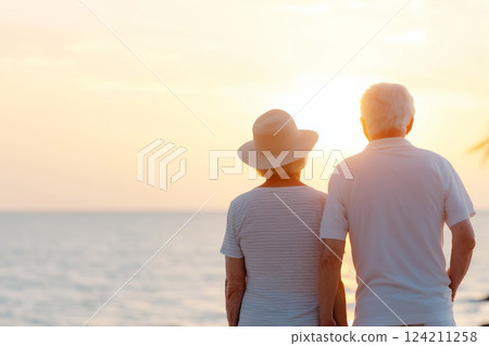 Romantic elderly couple enjoying a peaceful ocean sunset 124211258