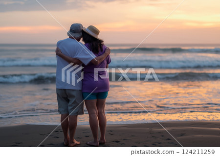 Romantic elderly couple enjoying a peaceful ocean sunset Romantic elderly couple enjoying a peaceful ocean sunset 124211259