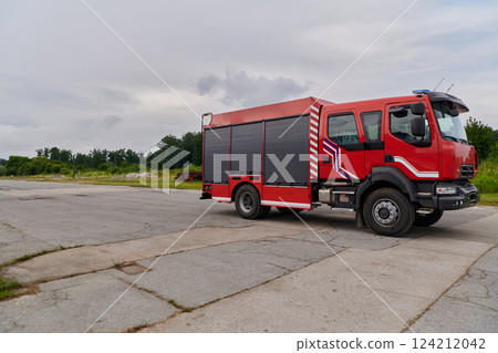 In this captivating scene, a state-of-the-art firetruck, equipped with advanced rescue technology, stands ready with its skilled firefighting team, prepared to intervene and respond rapidly to 124212042