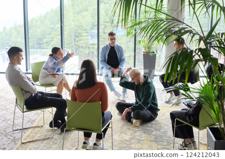 Corporate business team meeting with a manager or coach. Group of happy diverse, multiracial people sitting in a circle  124212043