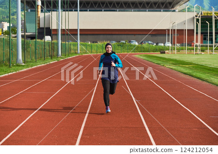 A muslim woman in a burqa sports muslim clothes running on a marathon course and preparing for upcoming competitions 124212054