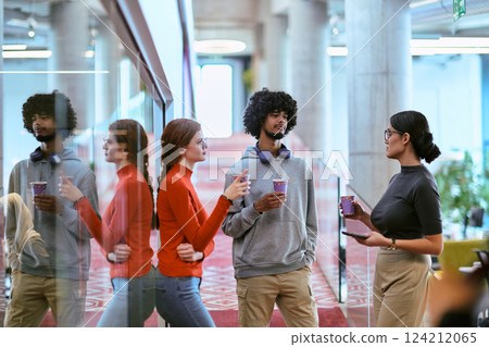 Amidst the modern glass walls of a startup office, a diverse group of colleagues, including an African American man, engage in a coffee-fueled discussion, exemplifying collaboration and innovation in 124212065