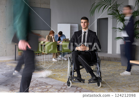 A businessman in a wheelchair navigating through a busy office, surrounded by his colleagues who are actively engaged in their work and collaboration A businessman in a wheelchair navigating through a busy office, surrounded by his colleagues who are actively engaged in their work and collaboration 124212098