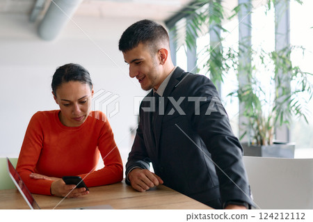 A young, diverse business team sitting together in a modern office, exchanging ideas and business plans, fostering collaboration and innovation for future success. 124212112