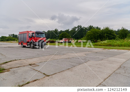 In this captivating scene, a state-of-the-art firetruck, equipped with advanced rescue technology, stands ready with its skilled firefighting team, prepared to intervene and respond rapidly to 124212149