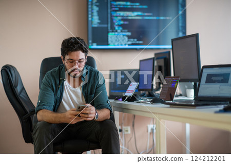 A programmer diligently testing smartphone applications A programmer diligently testing smartphone applications 124212201