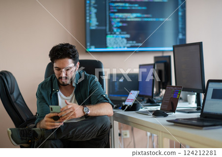 A programmer diligently testing smartphone applications  124212281