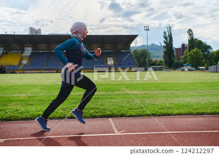 A muslim woman in a burqa sports muslim clothes running on a marathon course and preparing for upcoming competitions 124212297