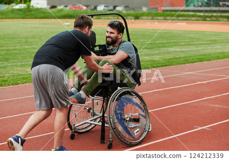 A cameraman filming the participants of the Paralympic race on the marathon course 124212339
