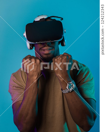 In an avant-garde scene, an African American man engages in cutting-edge virtual reality gaming, utilizing VR glasses to immerse himself in futuristic boxing games, set against a vivid blue background In an avant-garde scene, an African American man engages in cutting-edge virtual reality gaming, utilizing VR glasses to immerse himself in futuristic boxing games, set against a vivid blue background 124212343