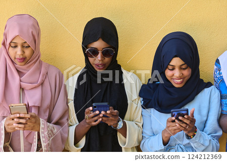 Diverse Teen Group Standing Together Against Wall Using Smartphones 124212369