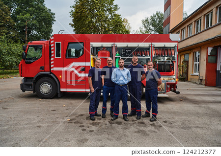 A skilled and dedicated professional firefighting team proudly poses in front of their state of the art firetruck, showcasing their modern equipment and commitment to ensuring public safety. 124212377
