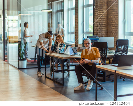 A diverse group of young business individuals congregates in a modern startup coworking center, embodying collaborative innovation and a dynamic atmosphere A diverse group of young business individuals congregates in a modern startup coworking center, embodying collaborative innovation and a dynamic atmosphere 124212404
