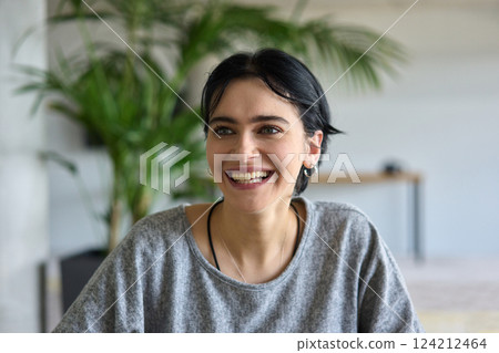 A close up portrait of a young businesswoman engaged in a professional meeting, confidently discussing ideas and strategies with her colleagues 124212464